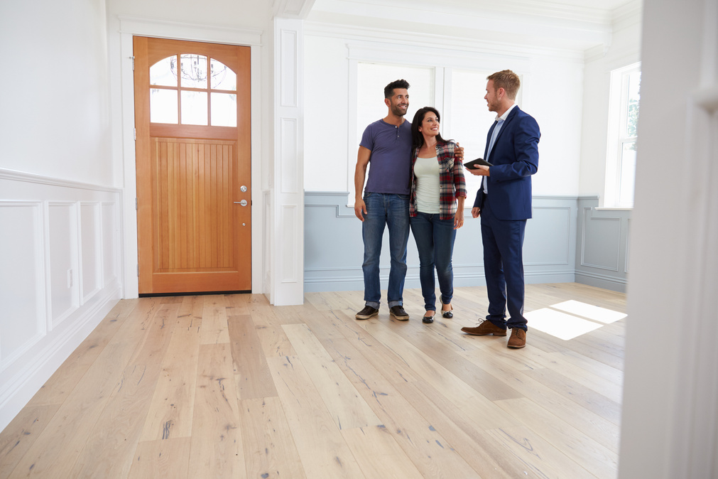 Realtor Showing Hispanic Couple around New Home
