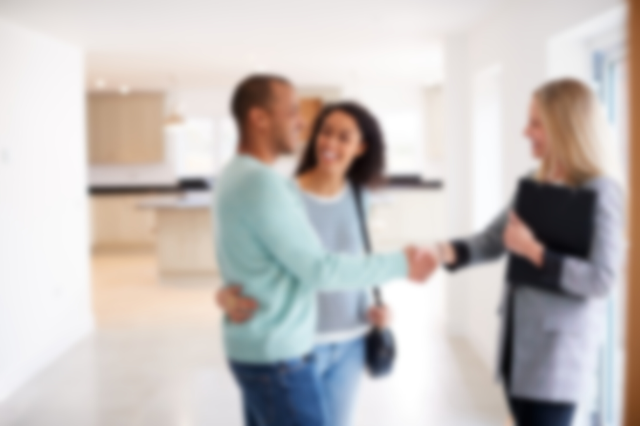 Female Shaking Hands with Couple Interested in Buying House